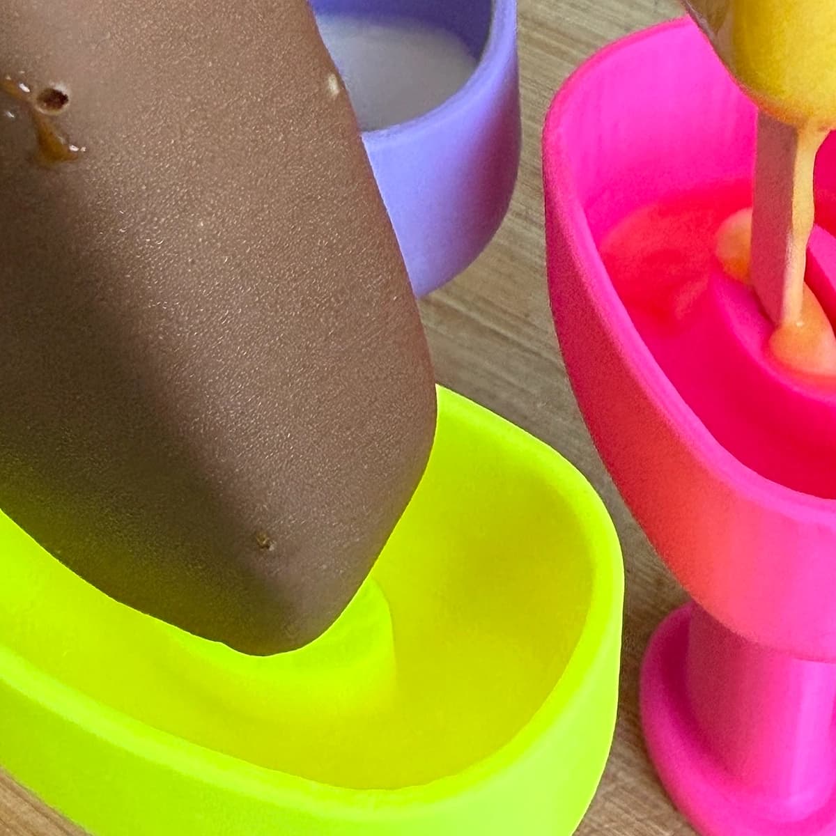 Soportes ergonómicos para helados de polo en colores vivos sobre mesa