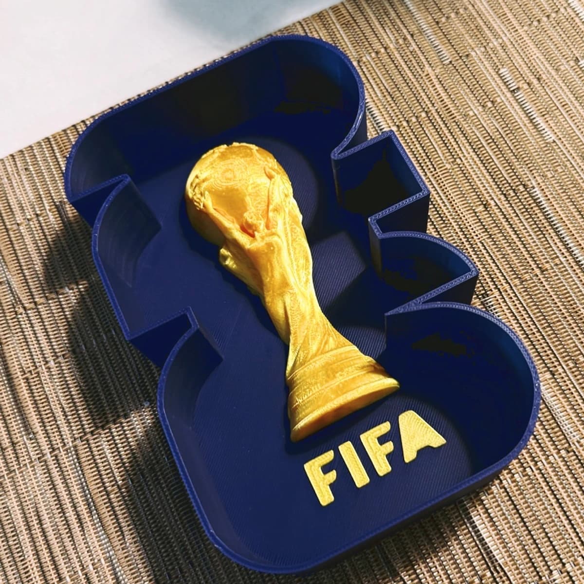Bandeja organizadora azul con figura de trofeo dorado integrada en relieve
